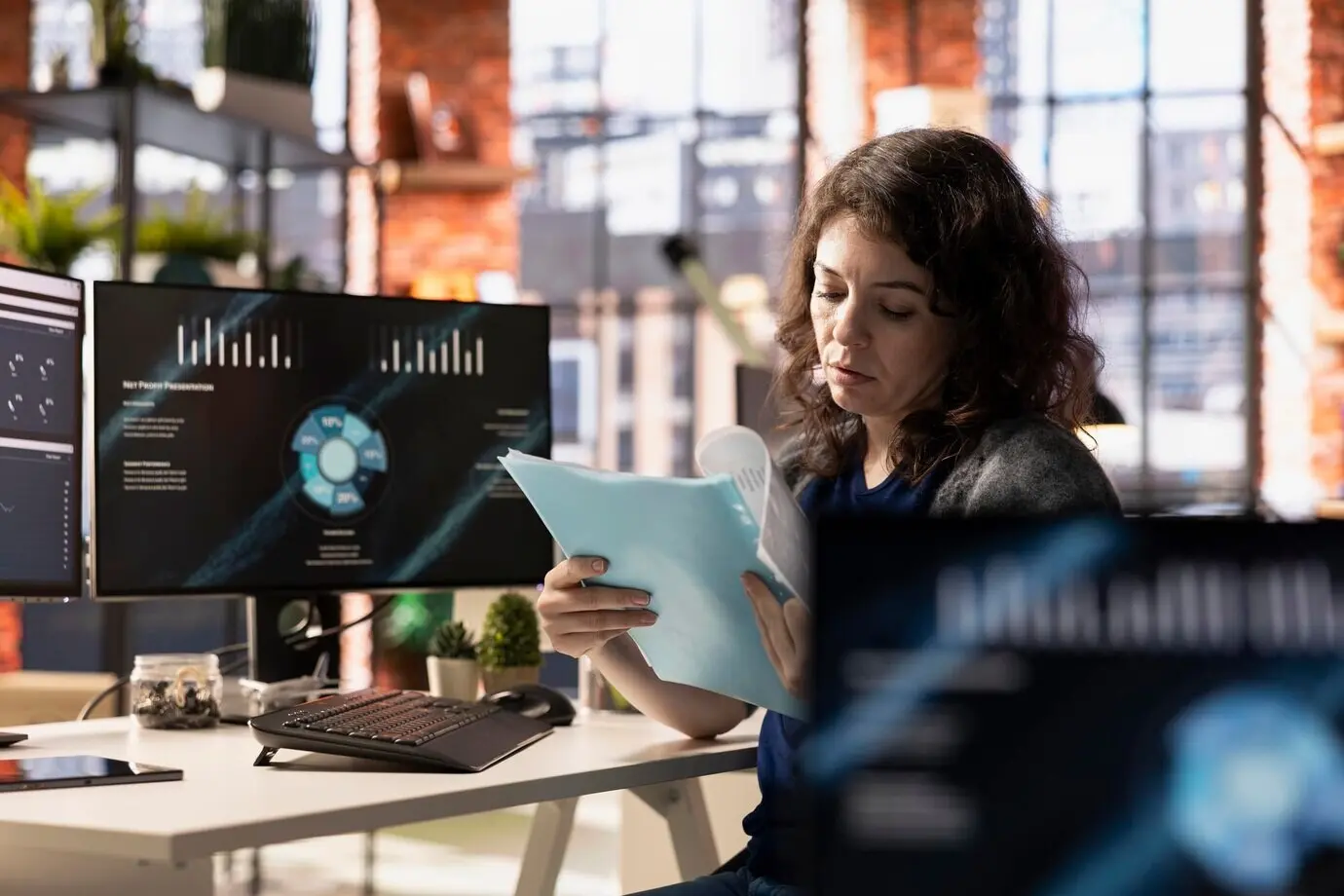 Молодой взрослый переписывает графики роста финансовой компании с экрана ПК.